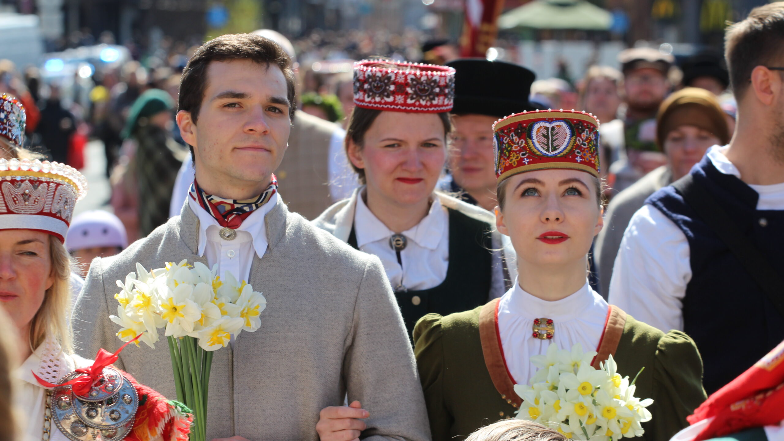 Tautas tērpos ģērbti cilvēki sapulcējušies kopējam gājienam līdz Brīvības piemineklim